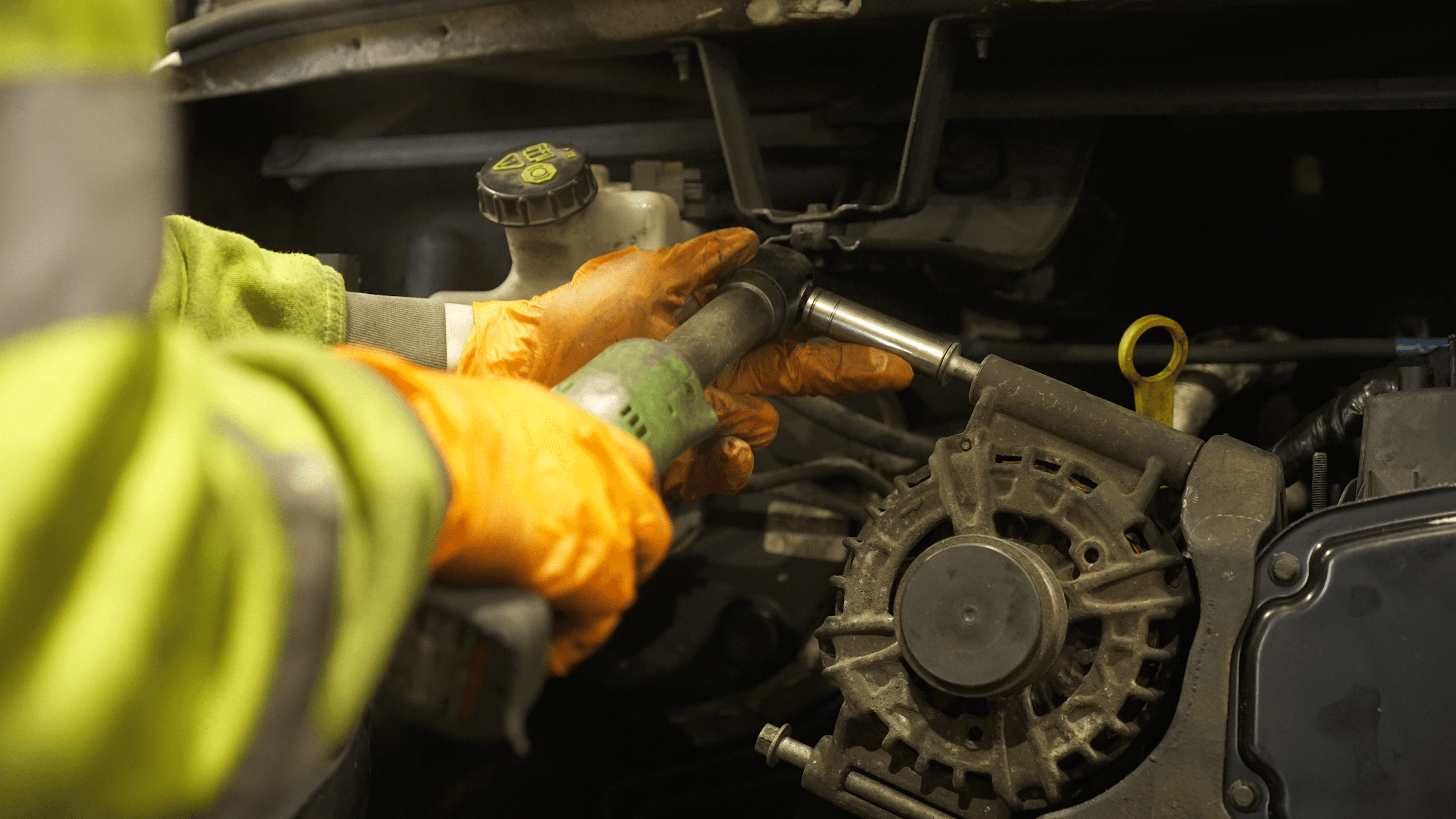 DT Hughes mechanic in hi-vis using a power tool to service a commercial vehicle engine at the commercial garage in Aintree, Liverpool